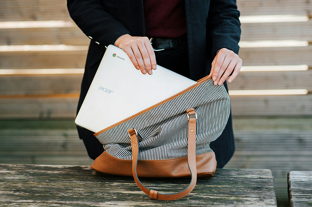 employee hands putting laptop into bag