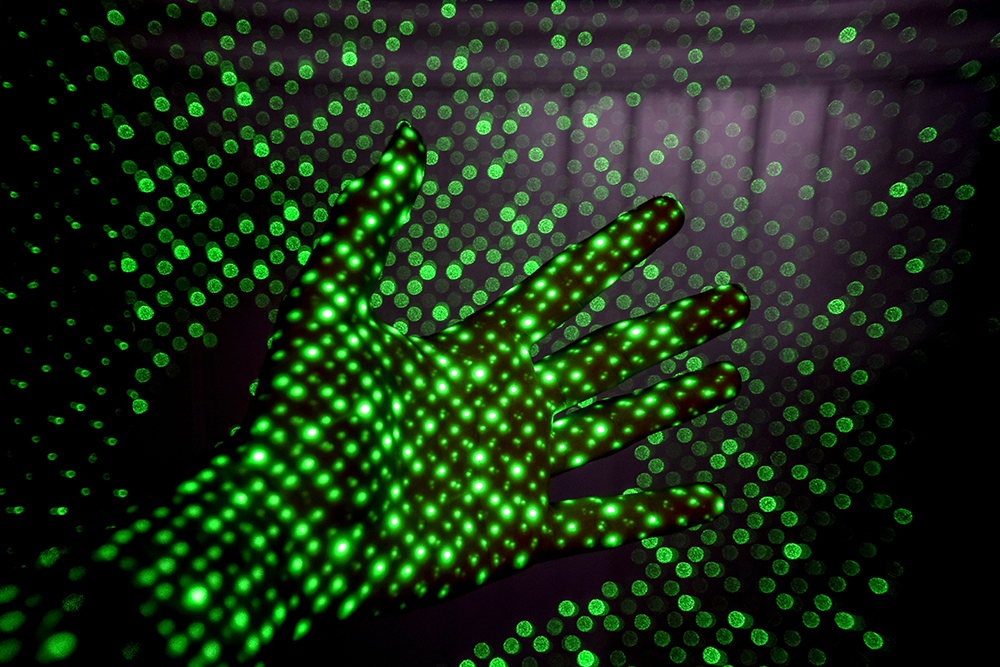 green dots overlaying hand - AI Sustainability